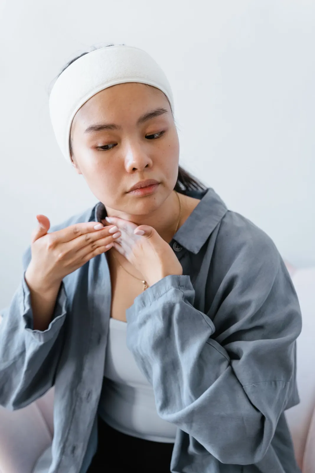 鏡の前で肌に触れる女性
